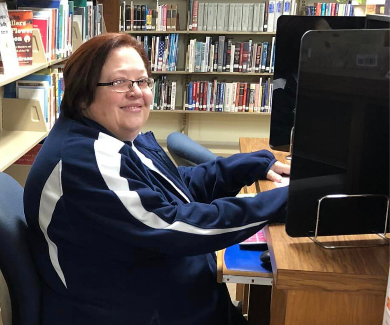 Dianne sitting at a desk in the library.